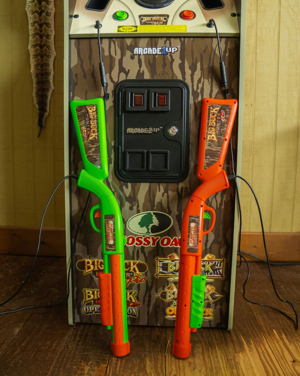 A detail of the front of Big Buck Hunter arcade game featuring the rifles used as game controllers.