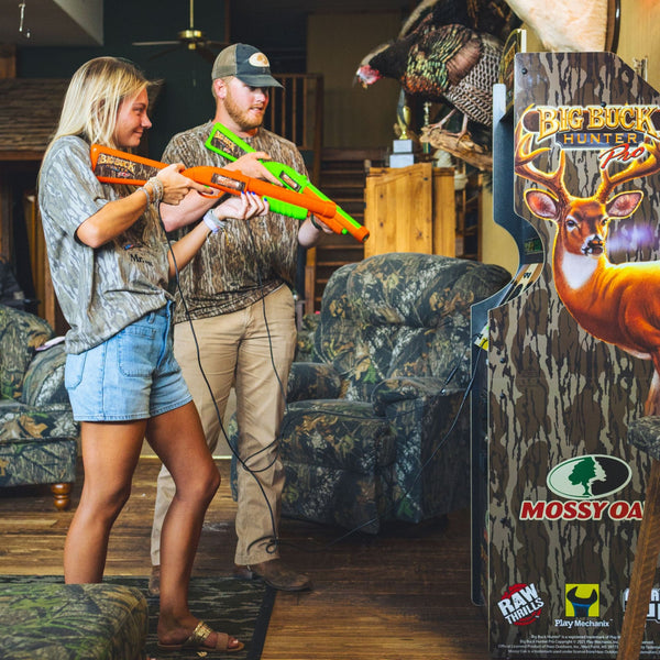 A man and woman play Big Buck Hunter arcade game